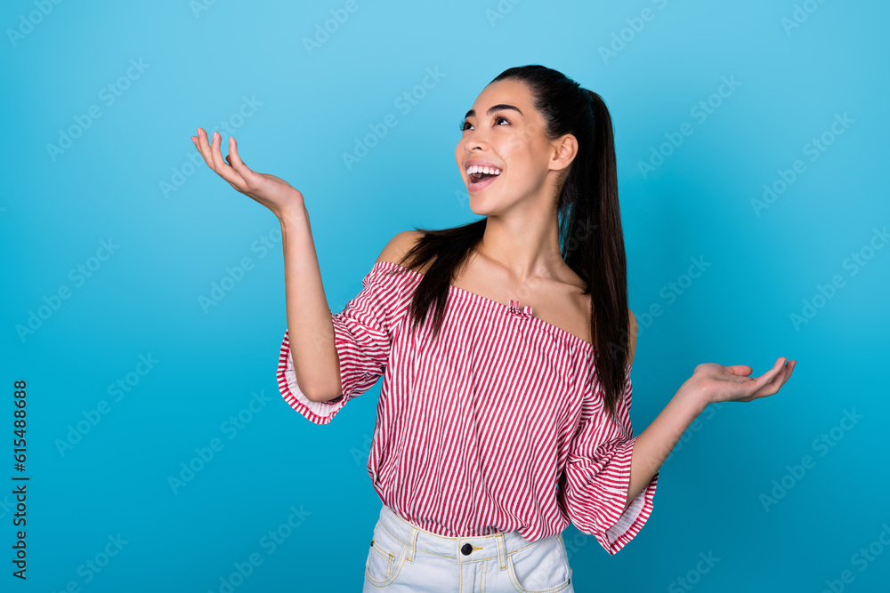 Photo of cute sweet girl dressed off shoulders striped blouse looking empty space isolated blue color background Photo of cute sweet girl dressed off shoulders striped blouse looking empty space isolated blue color background
