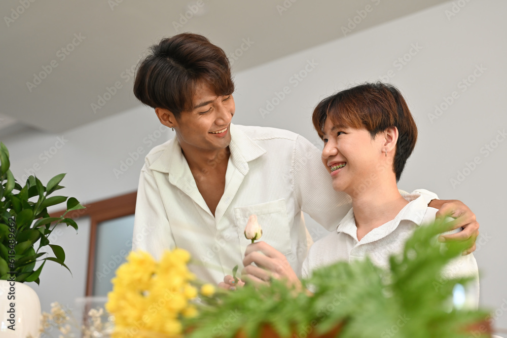 Portrait with Asian gay couple, They are helping to arrange a bouquet of flowers in the house.