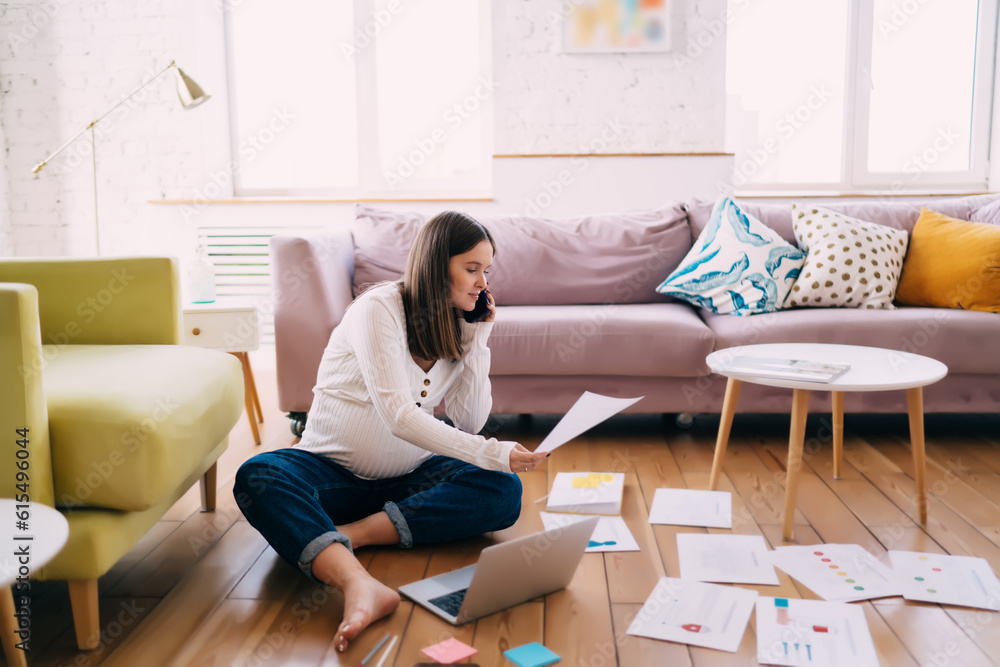 Pregnant woman working with documents and talking on smartphone Pregnant woman working with documents and talking on smartphone
