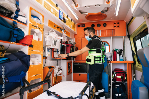 Emergency medical technician standing in ambulance car photo