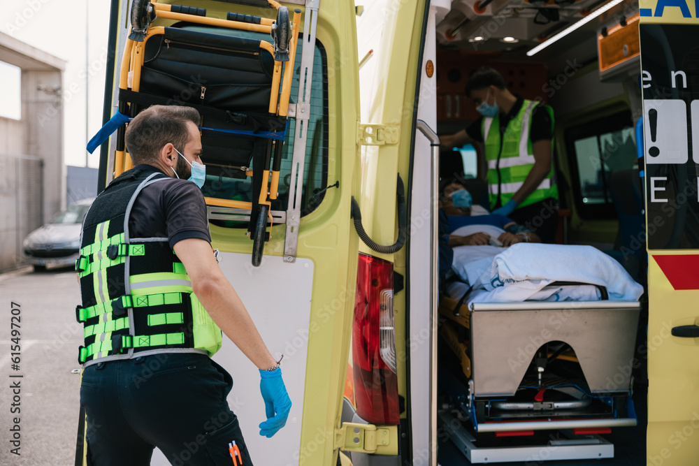 Emergency medical technician closing automobile with patient Emergency medical technician closing automobile with patient