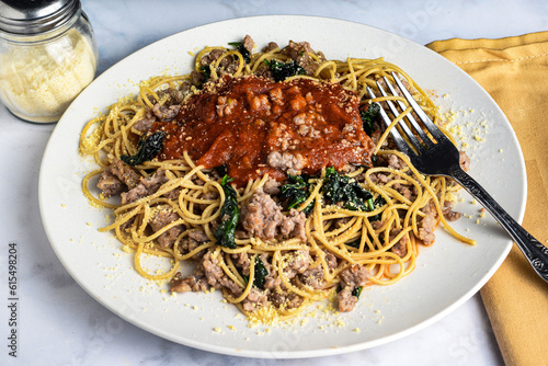 wheat spaghetti top with crumble sausage  and spinach,
