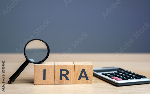 Wooden blocks with the word IRA - individual retirement account. Tax-advantaged account that individuals use to save and invest for retirement. Business and finance concept