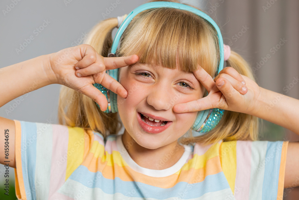 Portrait of happy overjoyed toddler girl kid in wireless headphones relaxing at home room choosing listening favorite energetic disco dancing music. Children weekends leisure activities. Lifestyles Portrait of happy overjoyed toddler girl kid in wireless headphones relaxing at home room choosing listening favorite energetic disco dancing music. Children weekends leisure activities. Lifestyles