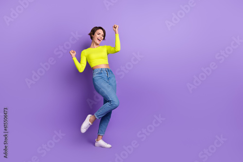 Fototapeta Naklejka Na Ścianę i Meble -  Full body photo of crazy young lady wearing levis jeans calvin klein crop top celebrating summer sale isolated on purple color background