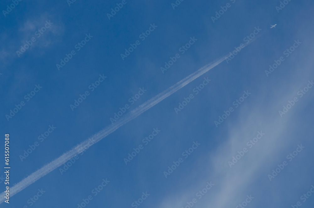 Airplane flying in the sky between clouds with smoke trail Airplane flying in the sky between clouds with smoke trail