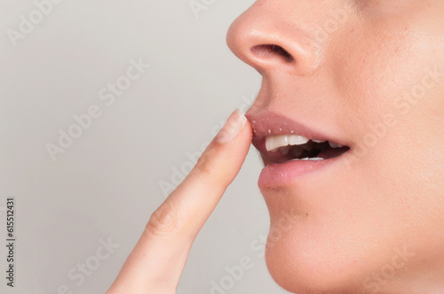 Crop woman exfoliating lips with sugar scrub photo