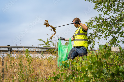 Young volunteer picking up litter in the nature