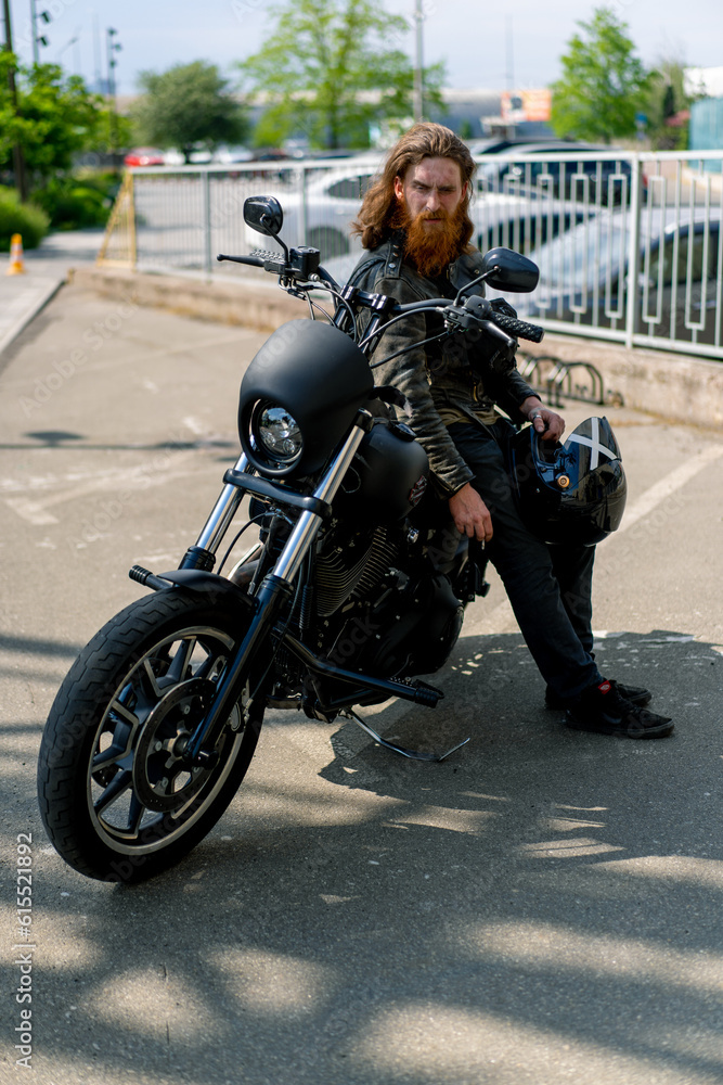 brutal red bearded biker sitting on a black motorcycle after a race smoking a cigarette thirst for speed motorsport concept