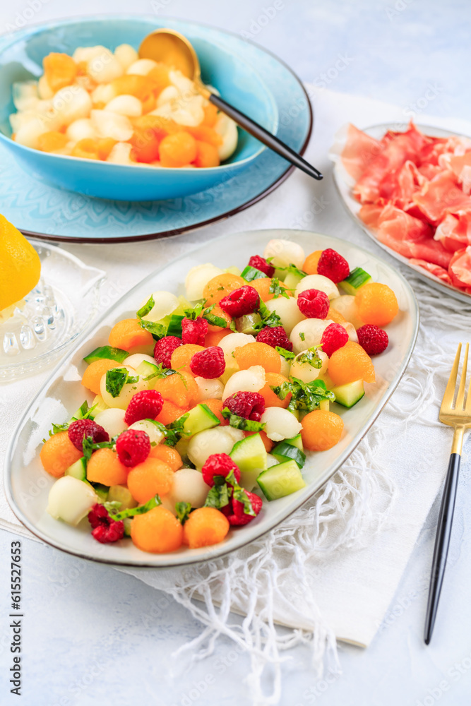 Summer light food. Cucumber and melon salad with raspberries and Prosciutto and pickled hot peppers Summer light food. Cucumber and melon salad with raspberries and Prosciutto and pickled hot peppers