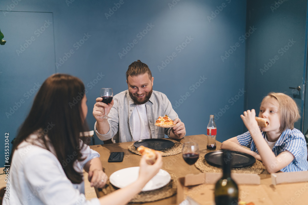 Cheerful man with wine having dinner with family