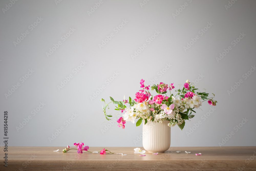 summer flowers in ceramic cup on light background summer flowers in ceramic cup on light background