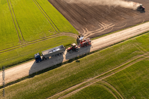 Fototapeta Naklejka Na Ścianę i Meble -  Drone photography of agricultural equipment replenishing seeds in field