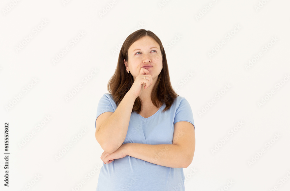 Portrait of standing with thoughtful serious smart expression, pondering answer, having doubts and suspicion, wearing blue T-shirt pregnant woman. Indoor studio shot isolated on white background. Portrait of standing with thoughtful serious smart expression, pondering answer, having doubts and suspicion, wearing blue T-shirt pregnant woman. Indoor studio shot isolated on white background.