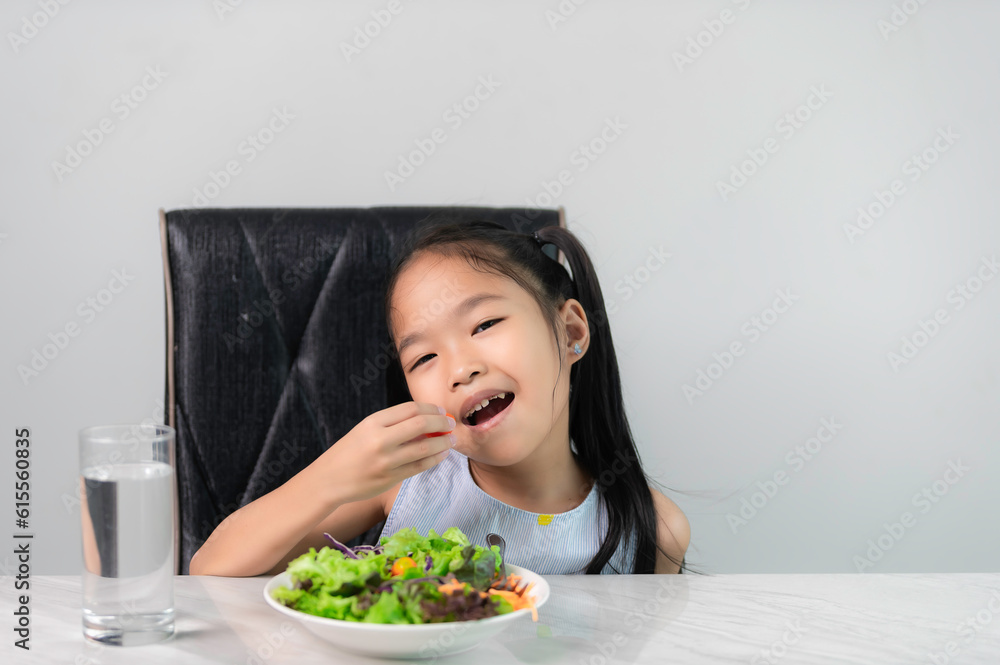 Little asian cute girl to eat healthy vegetables.Nutrition and healthy eating habits for kids concept.Children happy and like to eat vegetables. Little asian cute girl to eat healthy vegetables.Nutrition and healthy eating habits for kids concept.Children happy and like to eat vegetables.