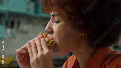 Black Woman Eating Burger. Female Biting Yummy Cheeseburger Close Up Slow motion.
