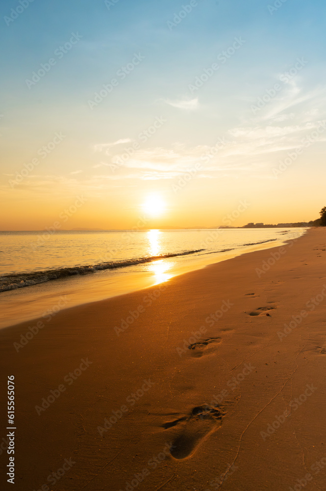 footprints in sand at beach with sunset