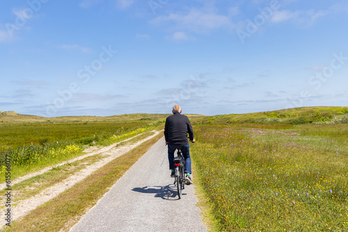 Tourist cycling at nature reserve Boschplaat at Wadden island Terschelling in Friesland province in The Netherlands photo