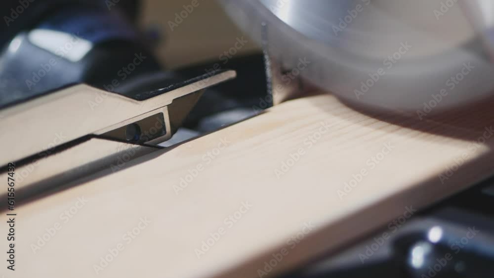The circular saw saws the board in slow motion in sunlight The circular saw saws the board in slow motion in sunlight