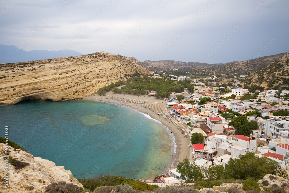View from the surrounding mountains on Matala with beach and sea on the Greek island of Crete, surrounded by limestone rocks with on the westside manmade caves, carved out of limestone cliffs