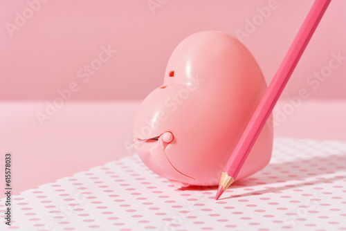 pink pencil tip touching desk on polka dot pink background with diary or copybook. Office or school stationery. Back to school. Drawing writing or storyteling concept. notes taking. meeting photo