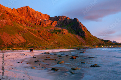 Sunset on a sandy beach with an illuminated rock - Skagen, Lofoten, Norway.