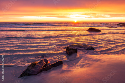 Sunset with illuminated water and sandy beach - Skagen, Lofoten, Norway.