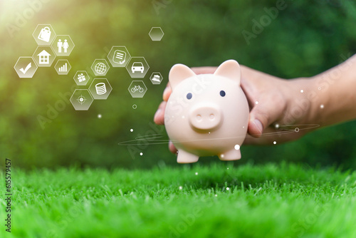 Money saving concept for the future plan and retirement fund, Hand putting coin into piggy, nature background, Business finance and investment.