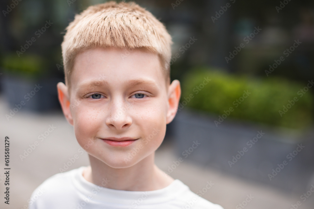 close up portrait of blond boy with blue eyes looking at camera and walking outdoors in city street close up portrait of blond boy with blue eyes looking at camera and walking outdoors in city street