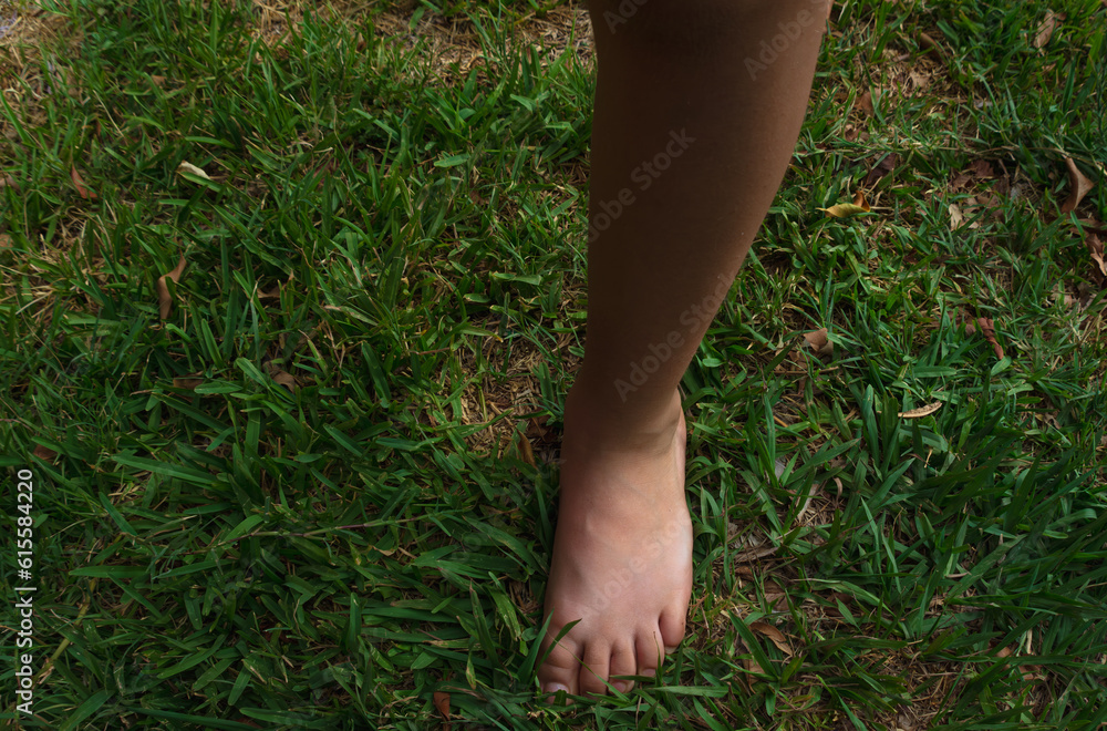 pie izquierdo de niño pequeño descalzo en el pasto, se tomo con luz natural