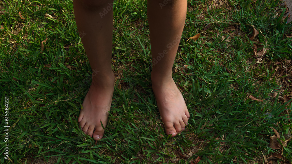 pies de niño pequeño latino, en el pasto descalzo, se tomo con luz natural y filtro polarizado.