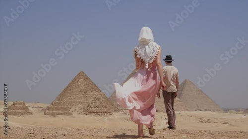 Woman in a white dress is running towards a man with a hat. 