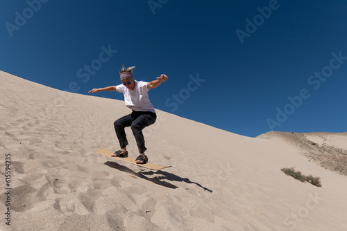 55 year old woman gliding across the sand on a sandboard