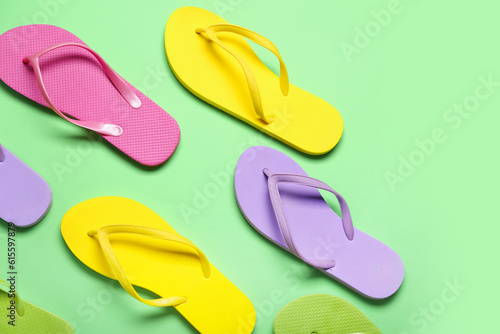 Colorful flip-flops on green background