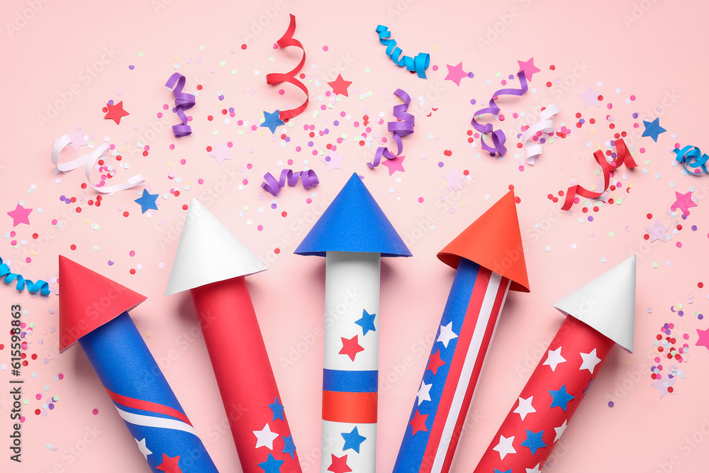 Obraz premium Firework rockets, confetti and serpentine for Independence Day on pink background