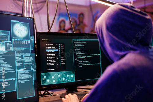 Obraz na plátně Hacker in hood running illegal malware on computer screen with multiple windows