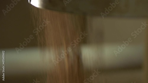 static slow motion macro shot of cocoa powder is poured out of metal device