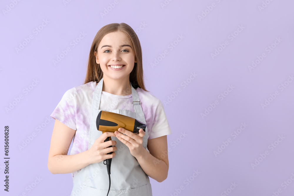 Female hairdresser with dryer on lilac background Female hairdresser with dryer on lilac background
