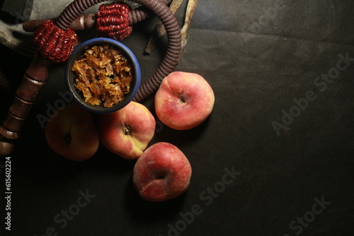 bowl of tobacco for hookah. smoking shiisha. berries and fruits on a dark background