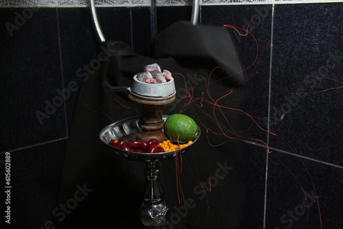 bowl of tobacco for hookah. smoking shisha. berries and fruits on a black background