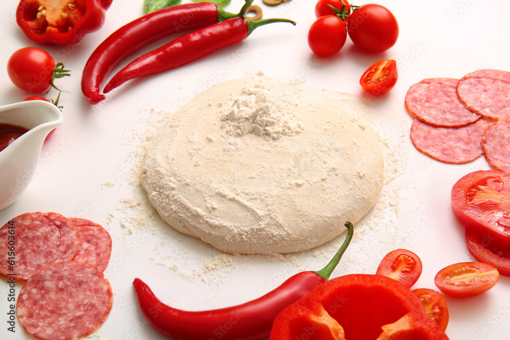 Raw dough and ingredients for preparing pizza on white background