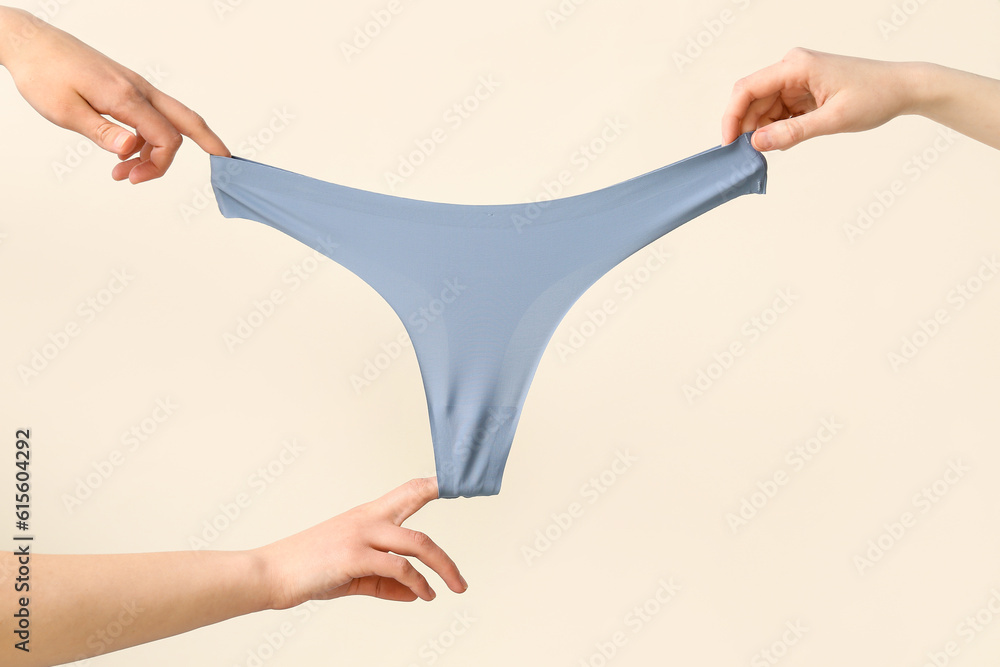 Female hands with stylish panties on light background, closeup