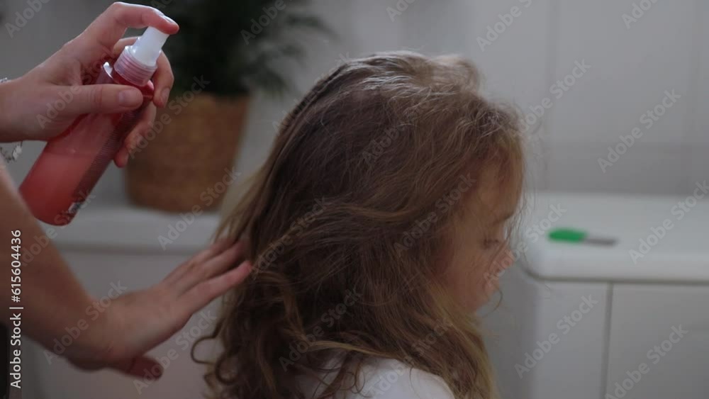 A woman helps to get rid of lice and parasites on the head of a little
