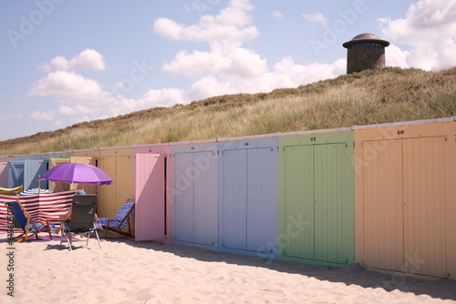 Beach in Domburg Netherlands,colorful beachhouse and blue sky. Men sitting under purple umbrella on the beach .High quality photo photo