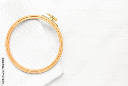 Foto Wooden embroidery hoop with canvas on white wooden background