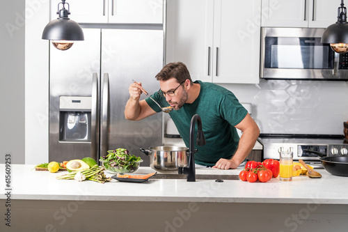 Male cook or chef cooking food in pan pot in kitchen. Process of preparing gourmet dish. Man cooking at home in kitchen, using pot. Chef cooking food. Handsome chef cook cooking concept.