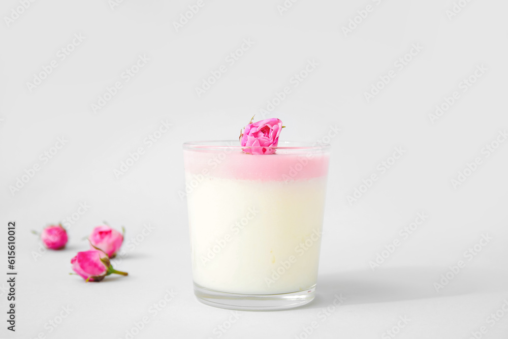 Glass of panna cotta with beautiful pink rose flowers on lilac background Glass of panna cotta with beautiful pink rose flowers on lilac background