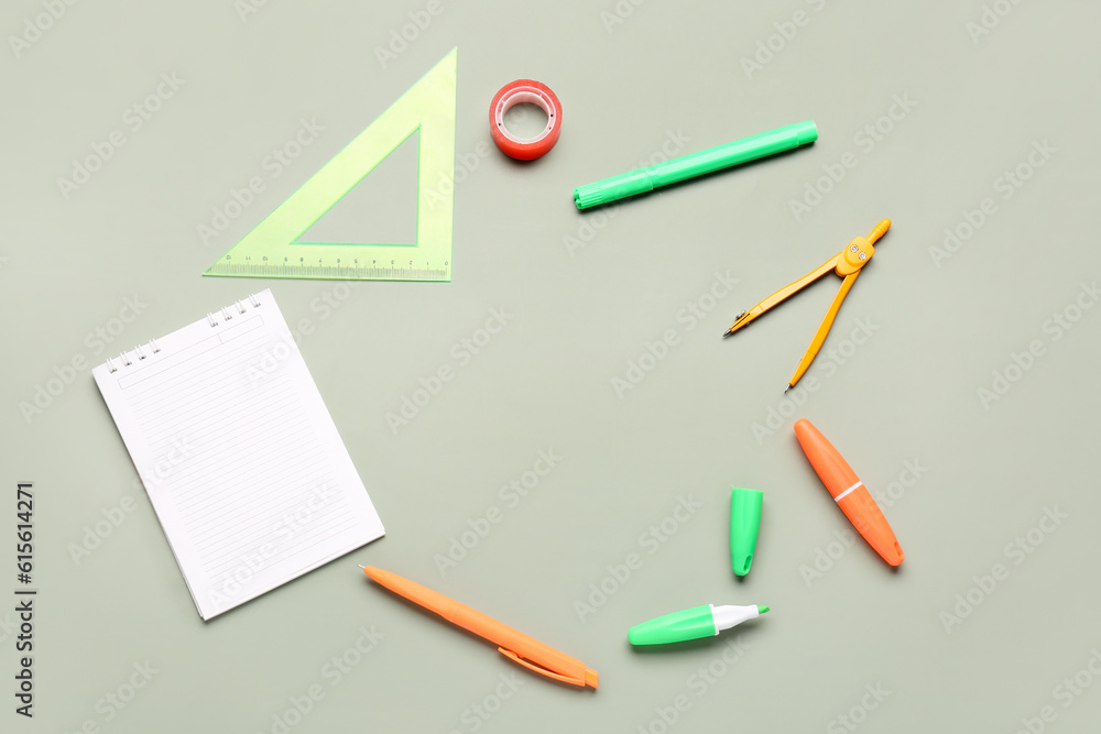 Open notebook with different stationery on grey background Open notebook with different stationery on grey background