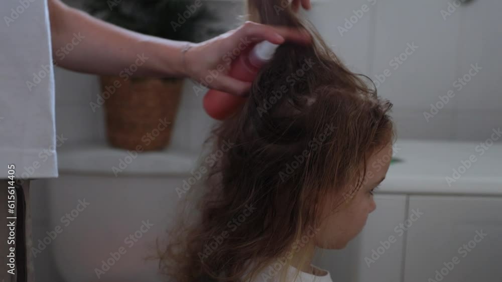 A woman helps to get rid of lice and parasites on the head of a little