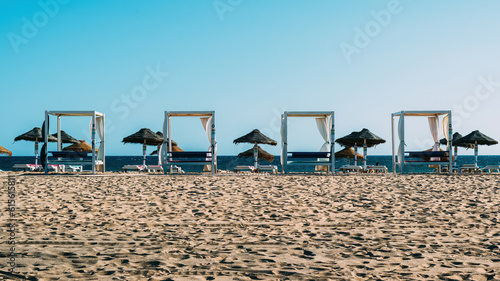 Luxurious sunloungers on the beach at Quarteira, Algarve, Portugal photo